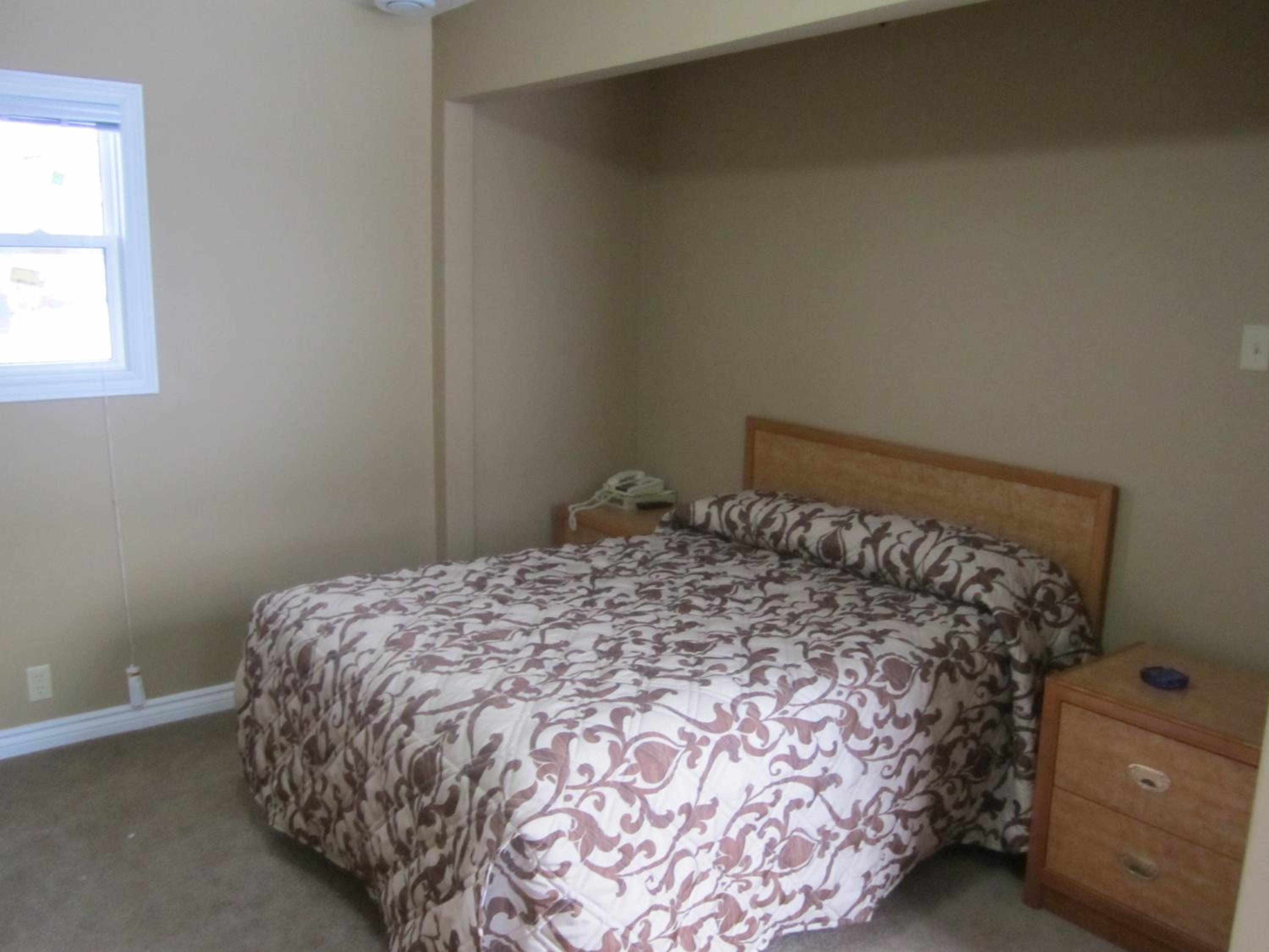 bed with a floral comforter and a night stand