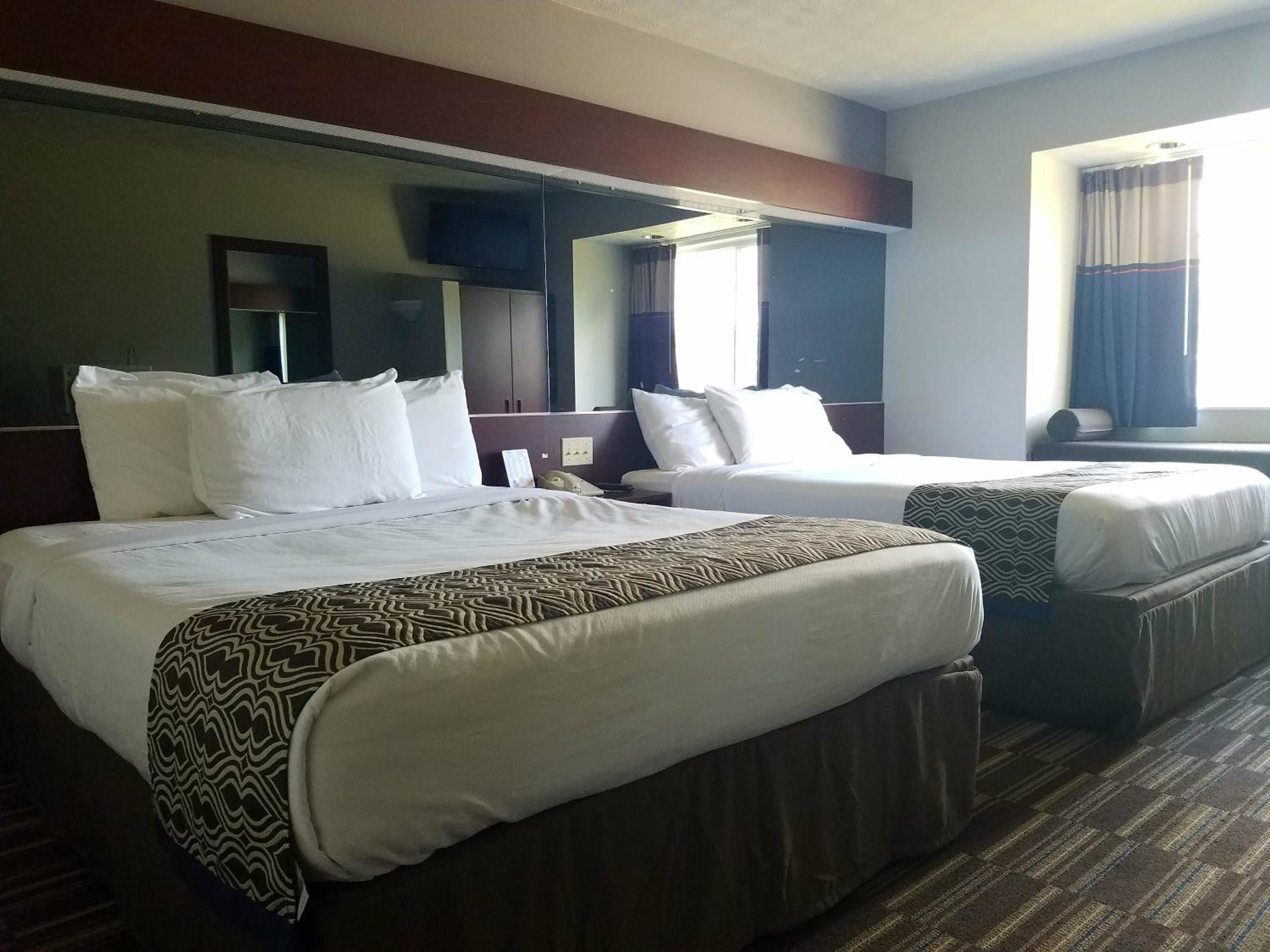 hotel room with two queen sized beds and a flat screen tv