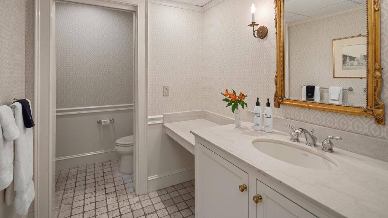Hotel bathroom with sink, mirror, and toilet