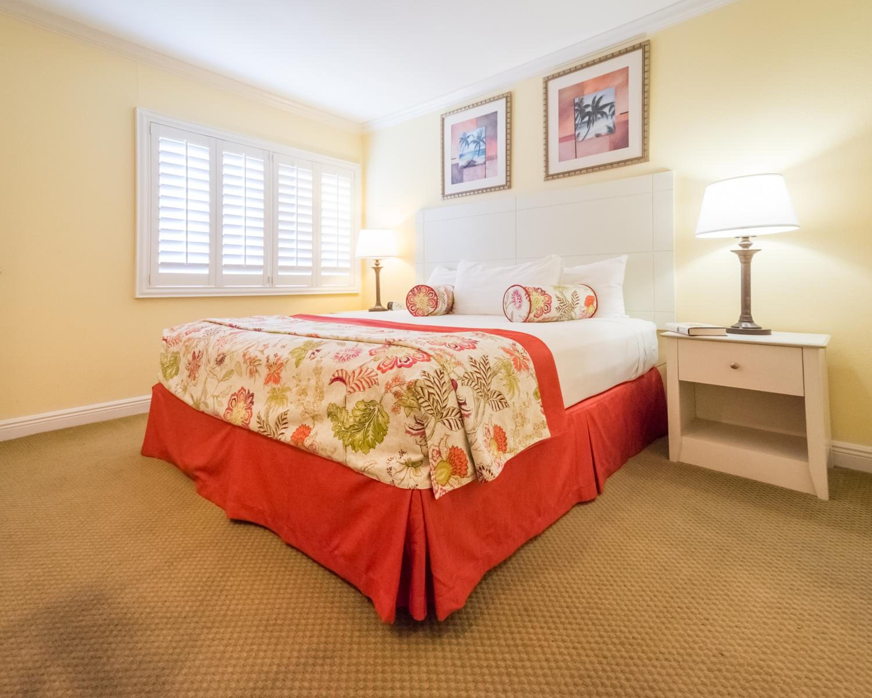 Bright yellow bedroom with red bed skirt and floral bedding