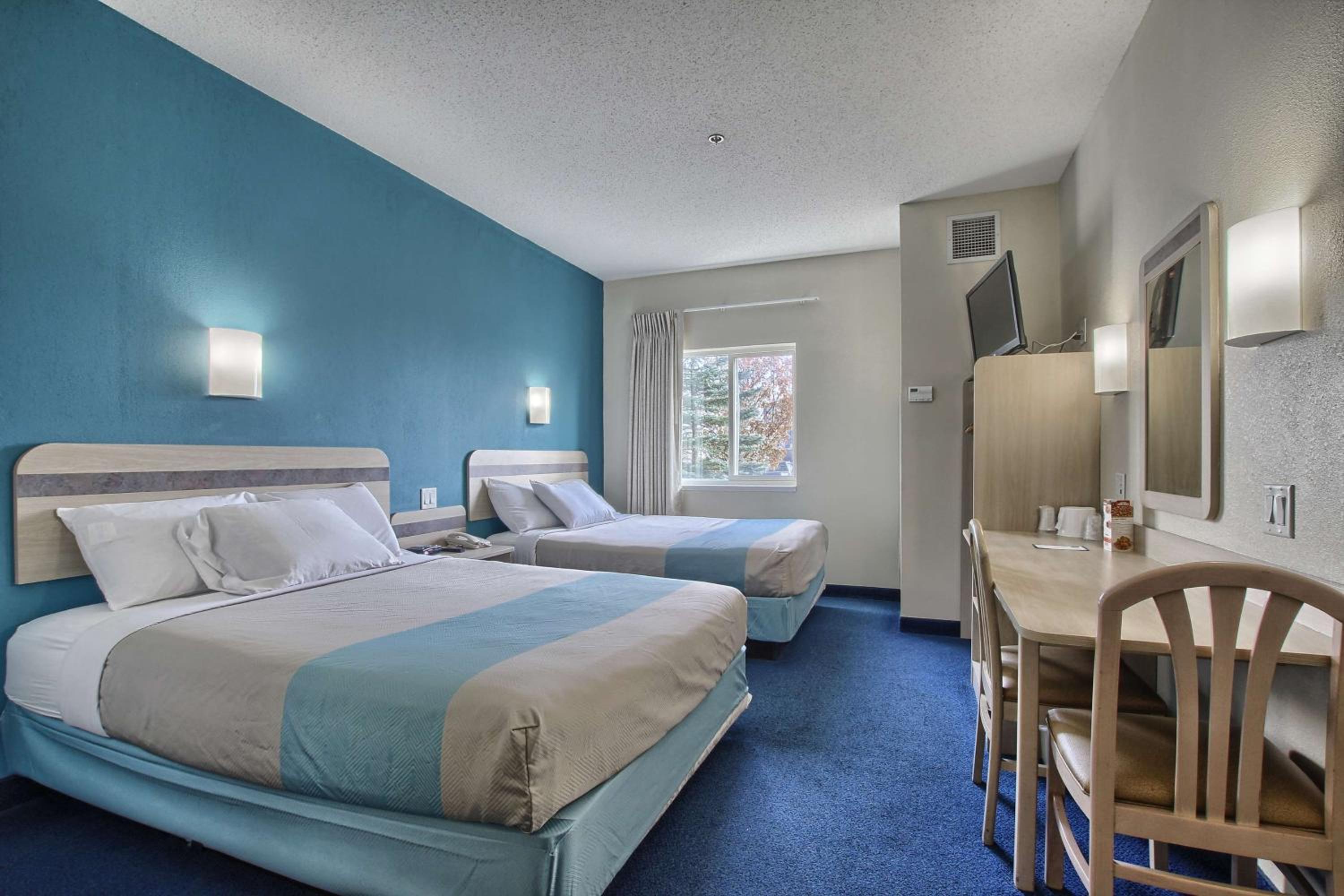 hotel room with two beds and a desk in it