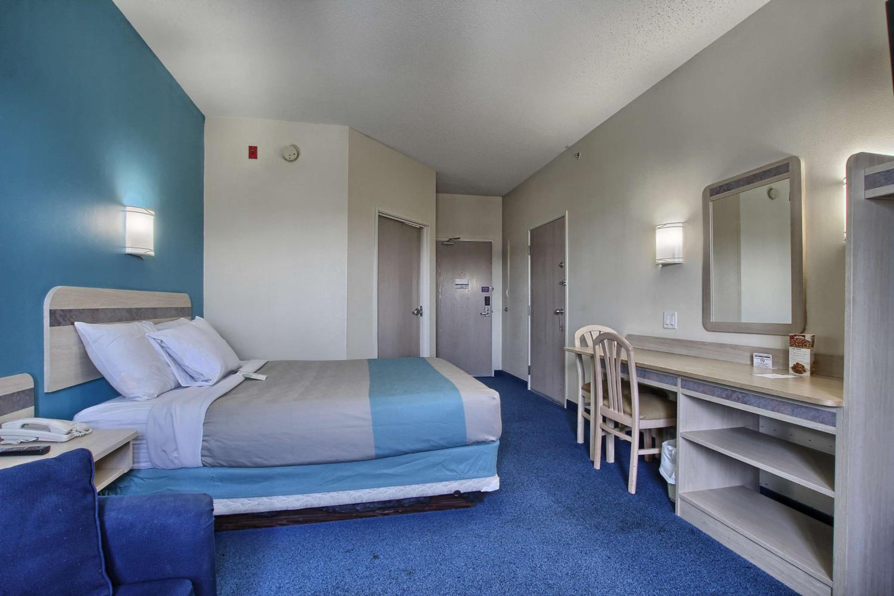 hotel room with a bed, desk, and chair