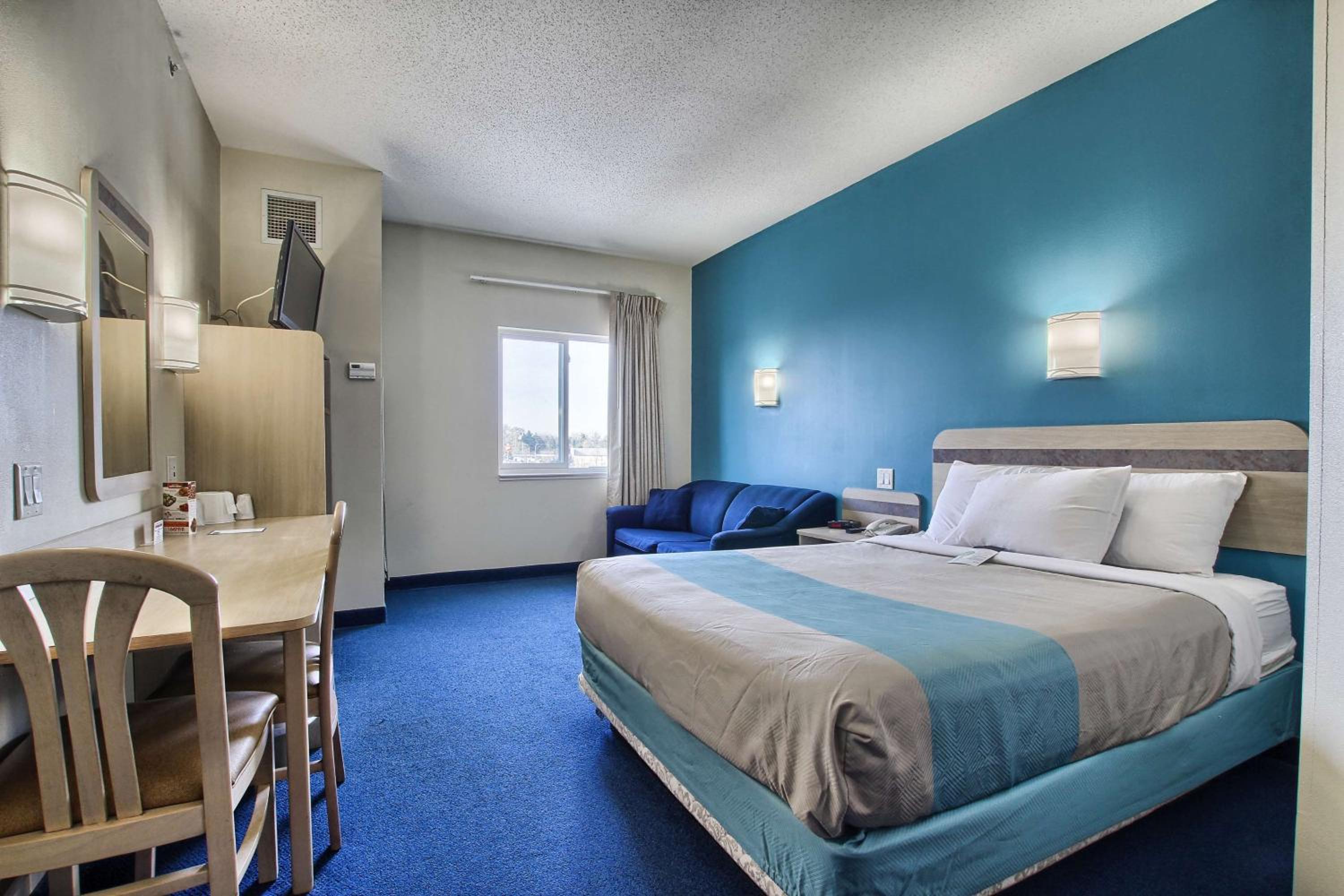 hotel room with a bed, desk, and chair
