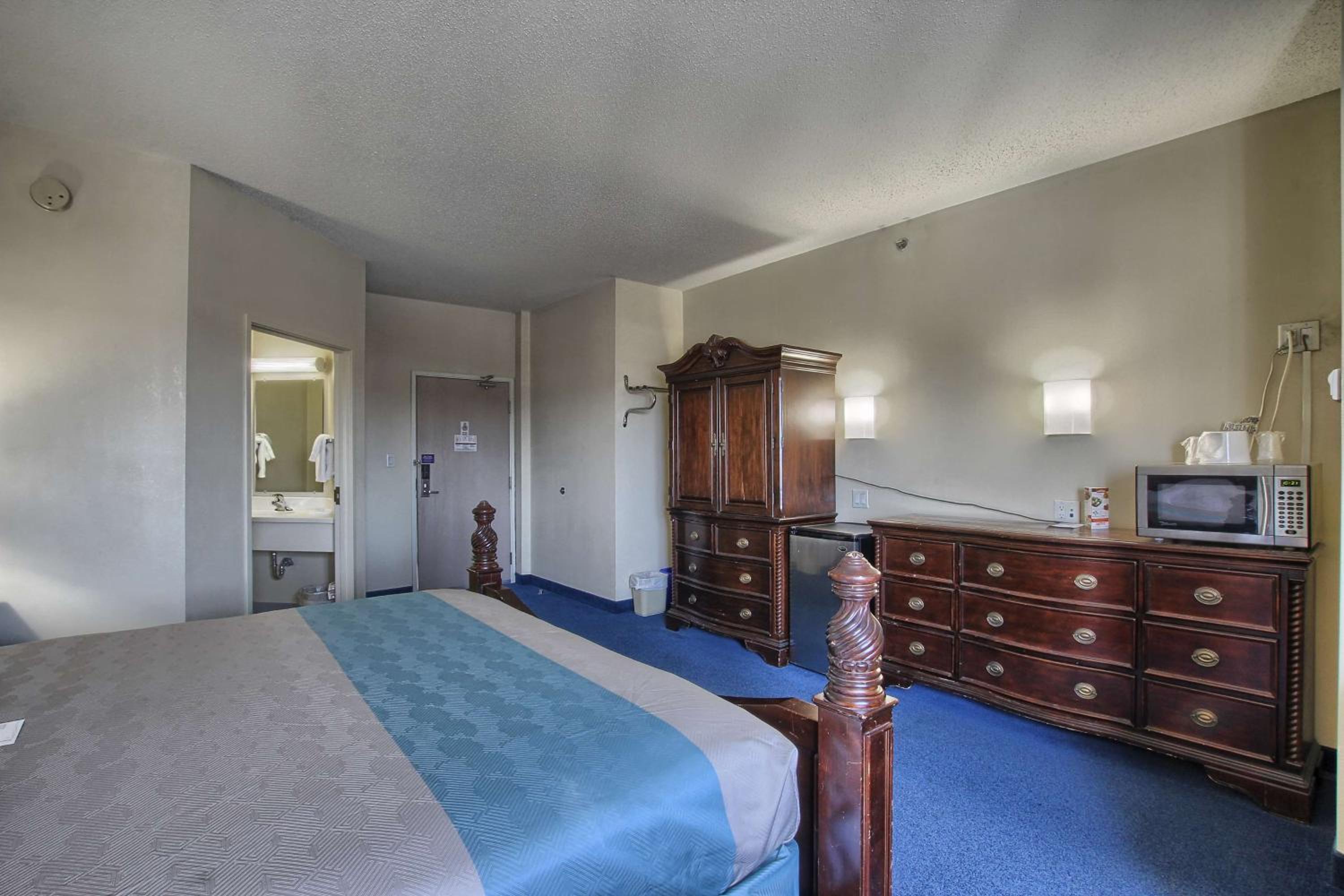 hotel room with a bed, dresser, and television