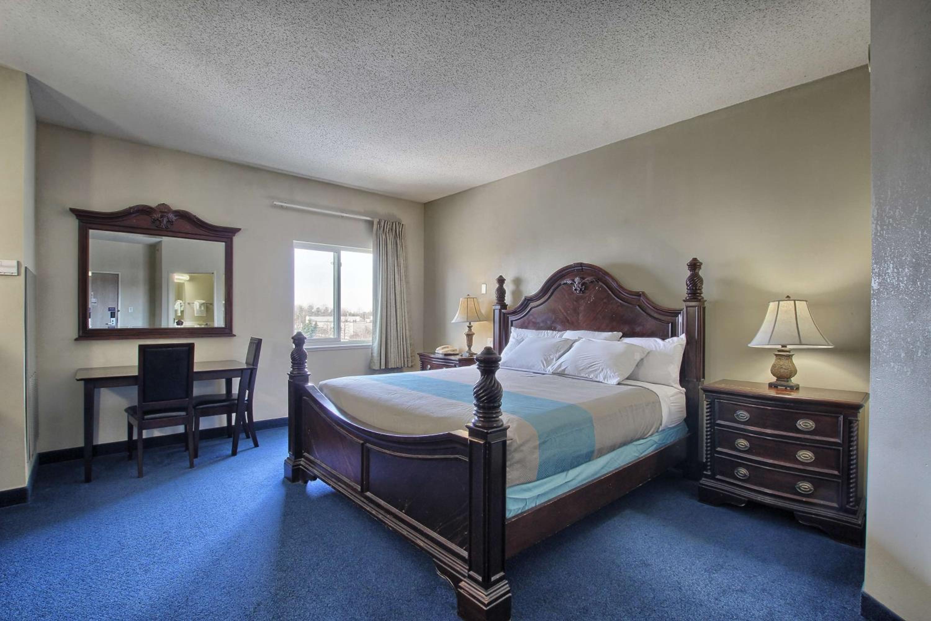 hotel room with a bed, desk, and chair