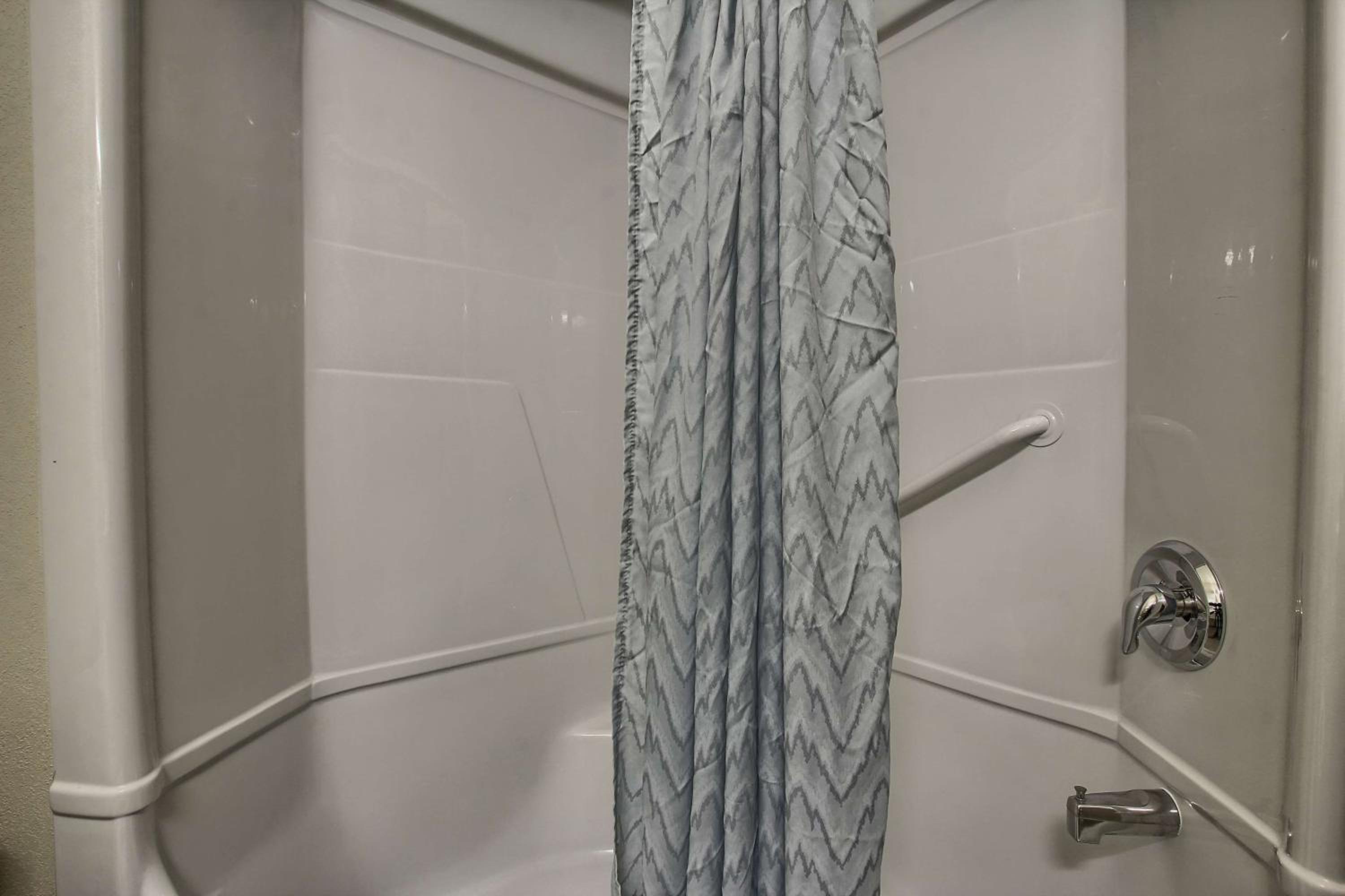 shower curtain hanging in the corner of the bathtub