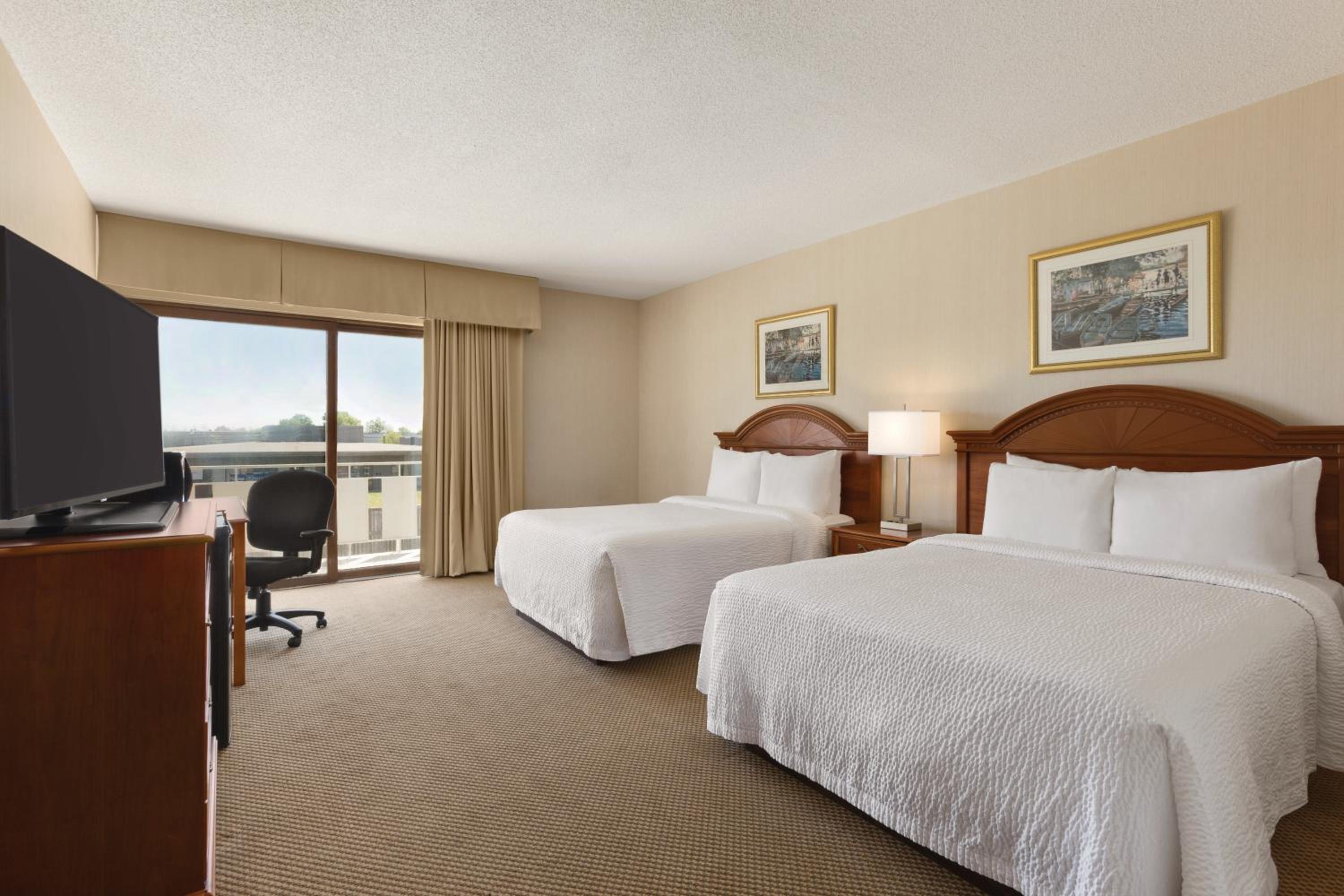 hotel room with two beds and a flat screen tv