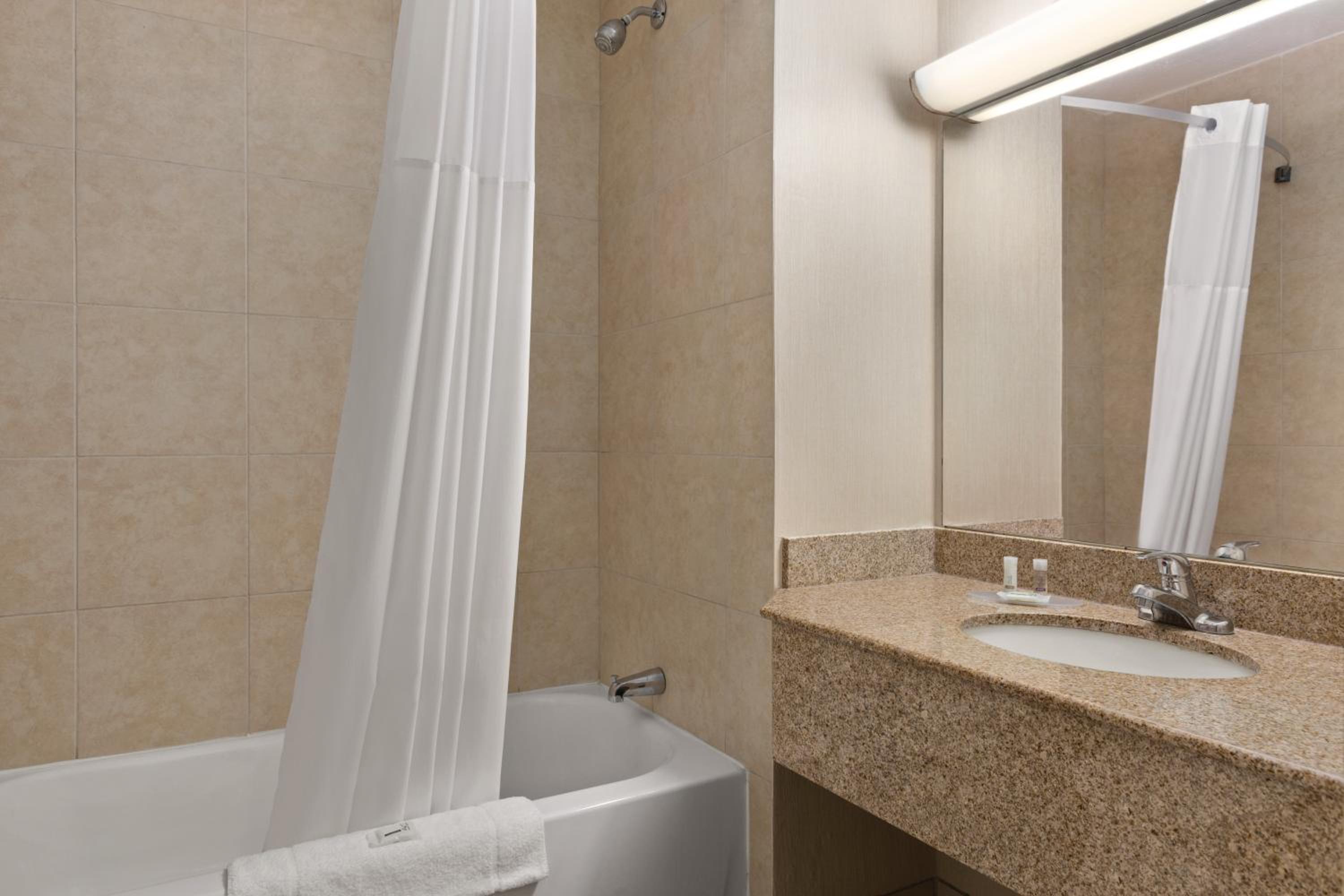 bathroom with a bathtub, sink, and mirror