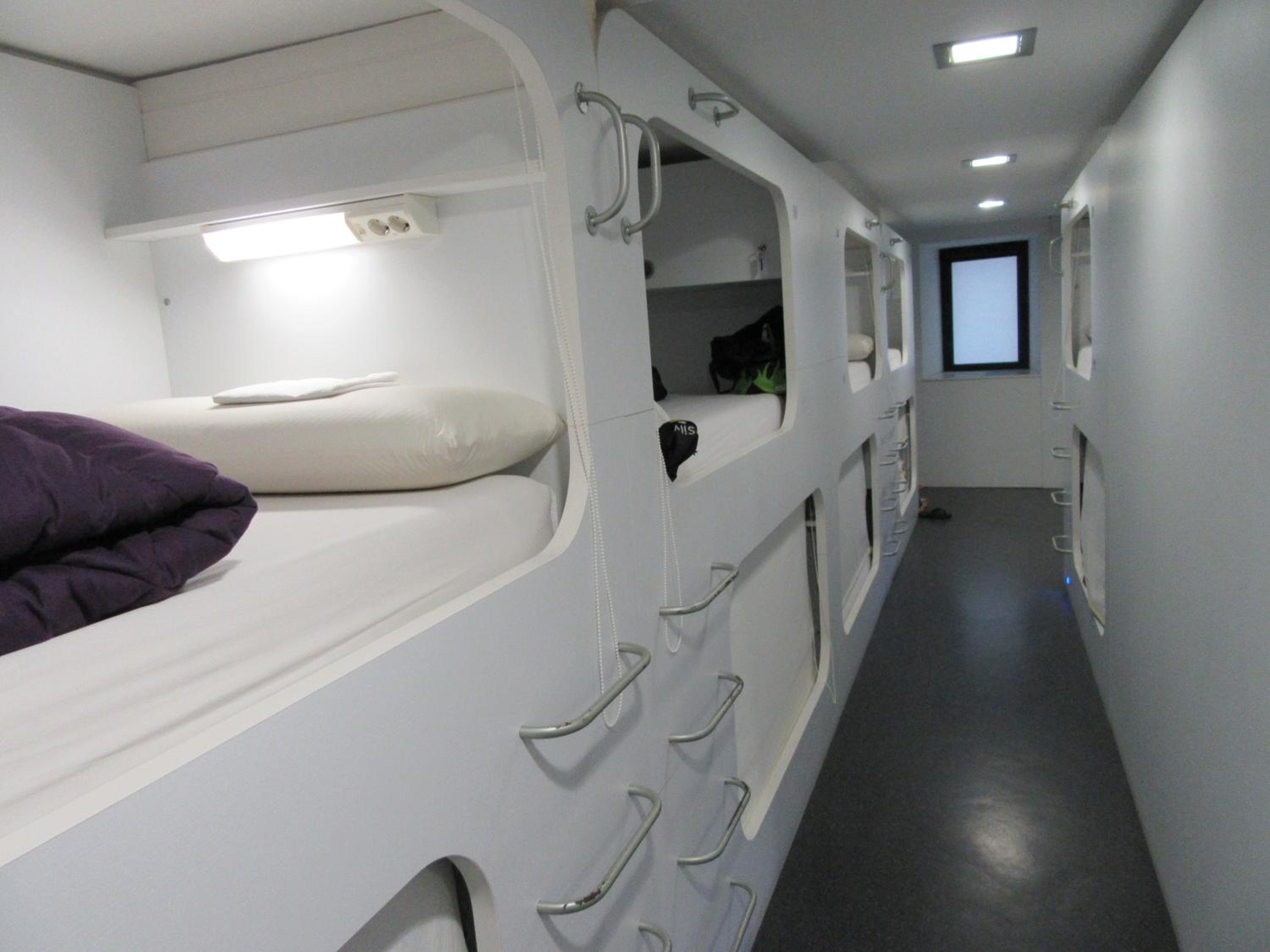 Cama individual en habitación compartida con baño compartido.