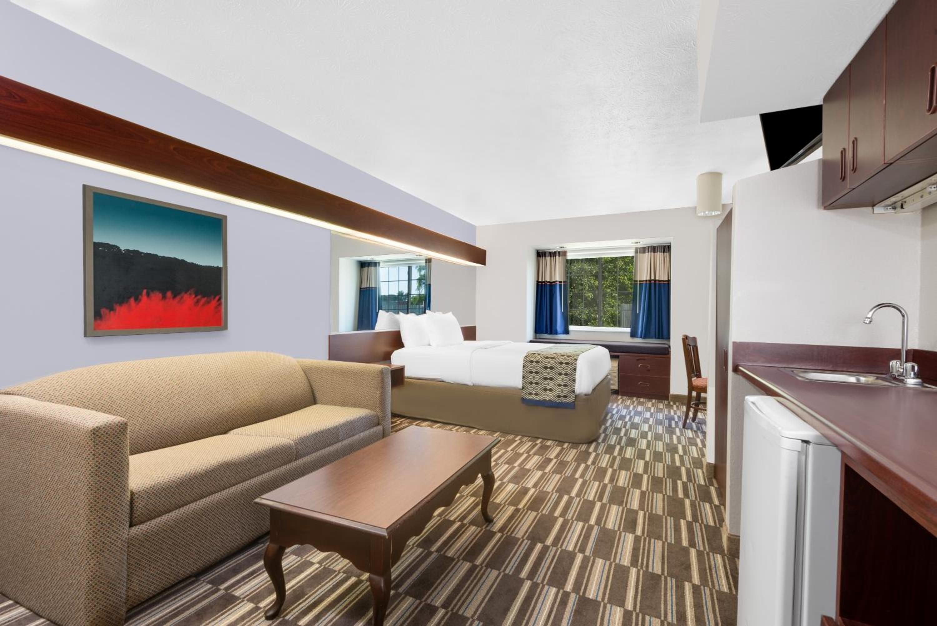 hotel room with a couch, coffee table and kitchenette