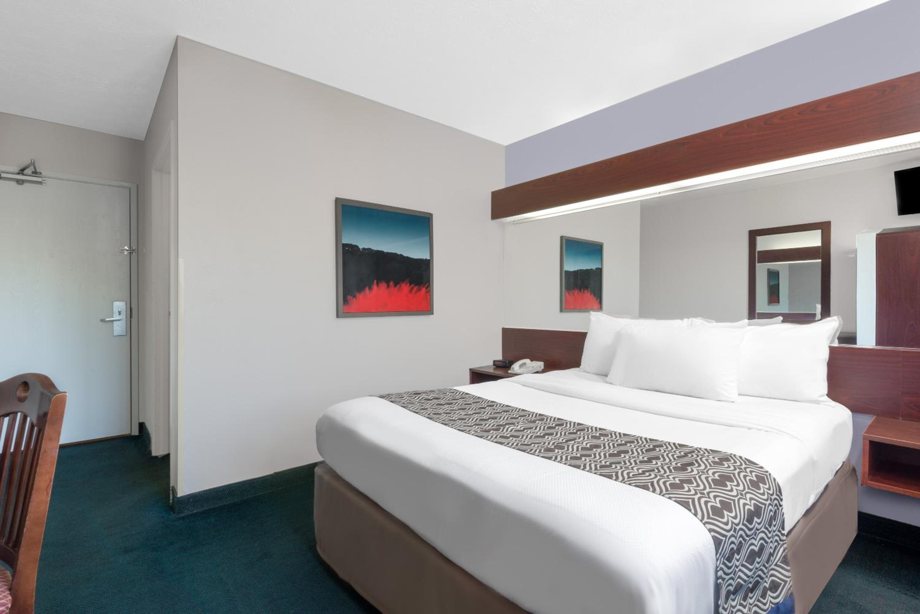 hotel room with a bed, desk, and television