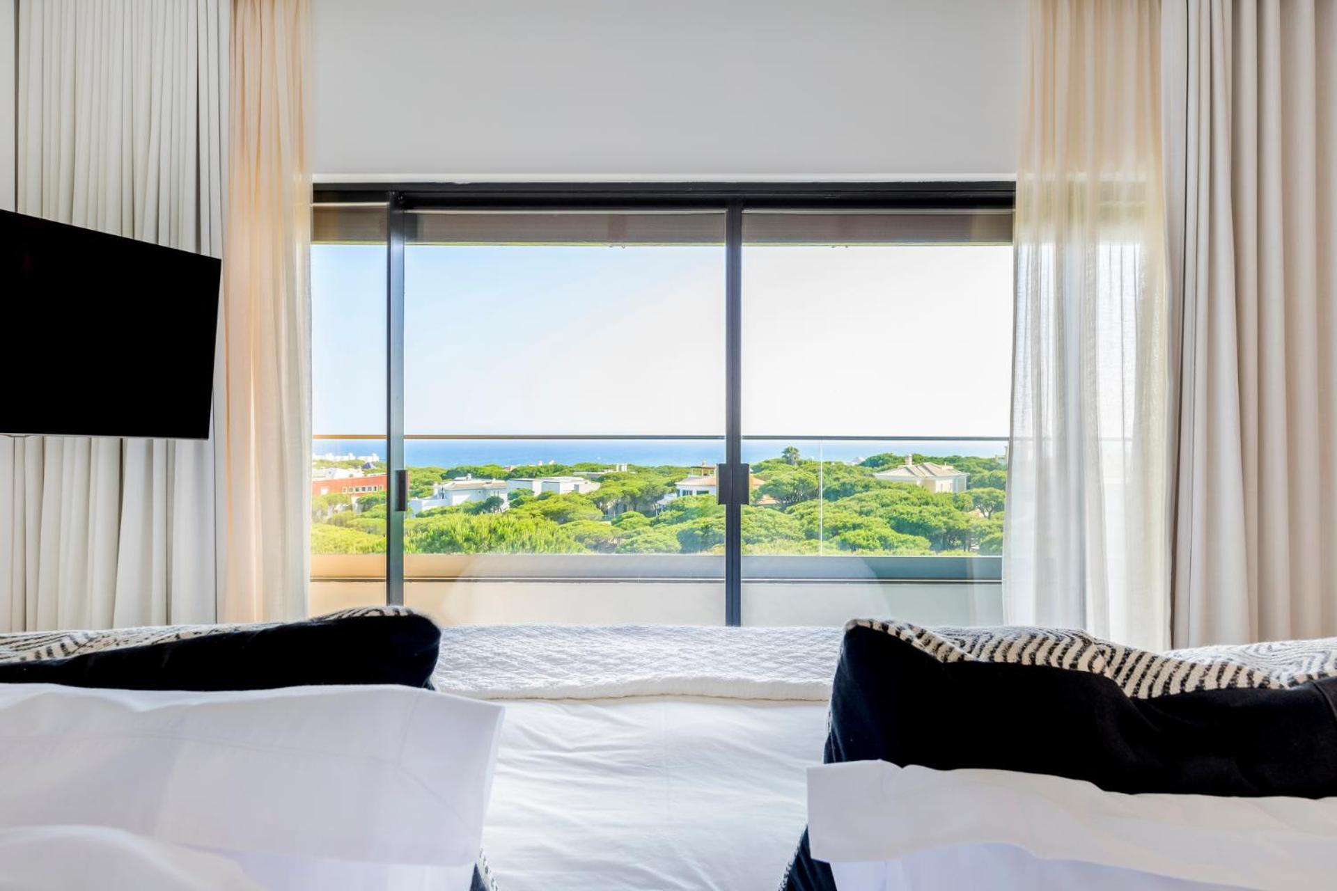 hotel room with a view of the ocean and trees