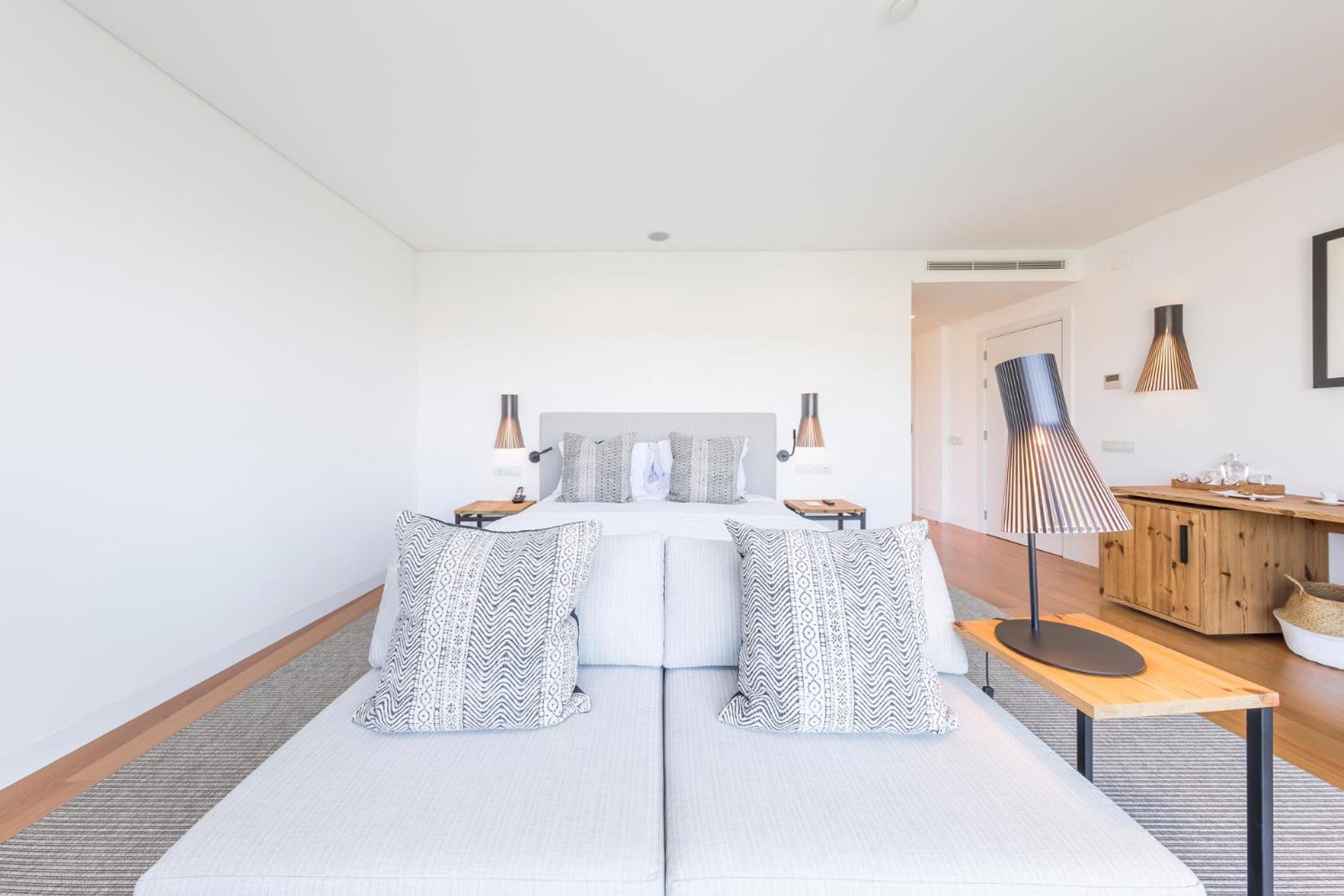 bedroom with a white bed and two lamps on either side of the bed