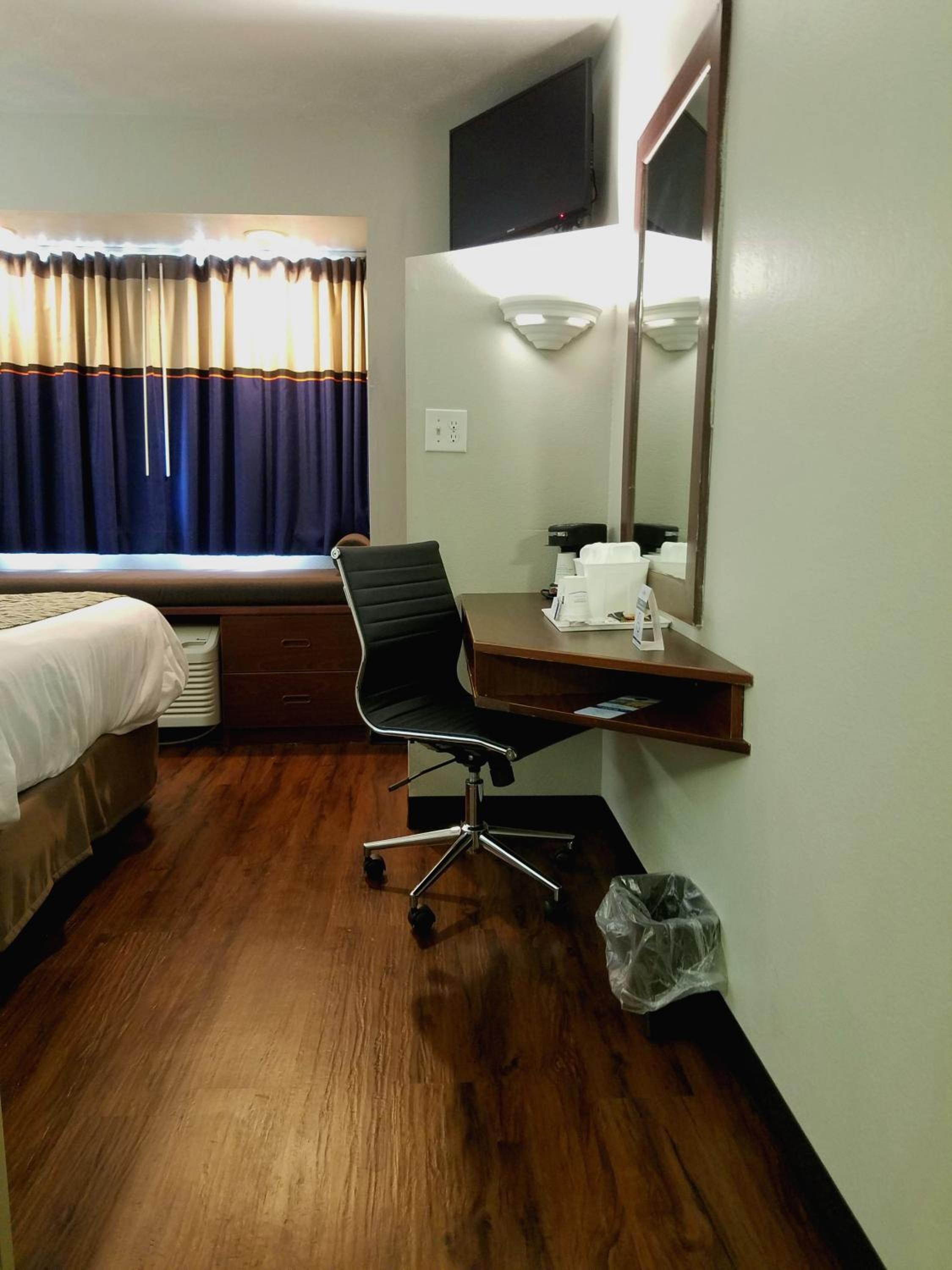 hotel room with a desk, chair, and bed