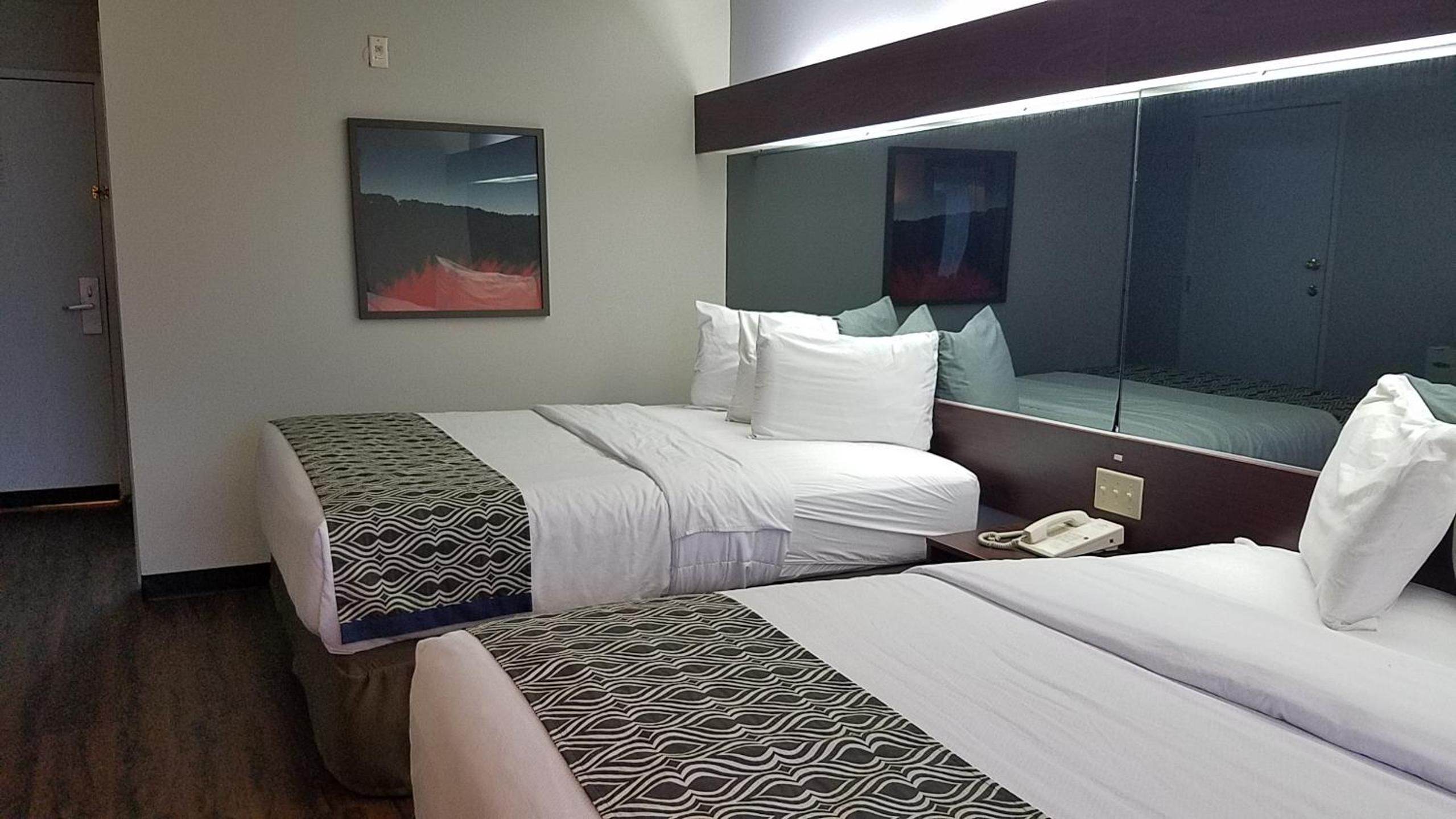 hotel room with two beds and a large mirror on the wall