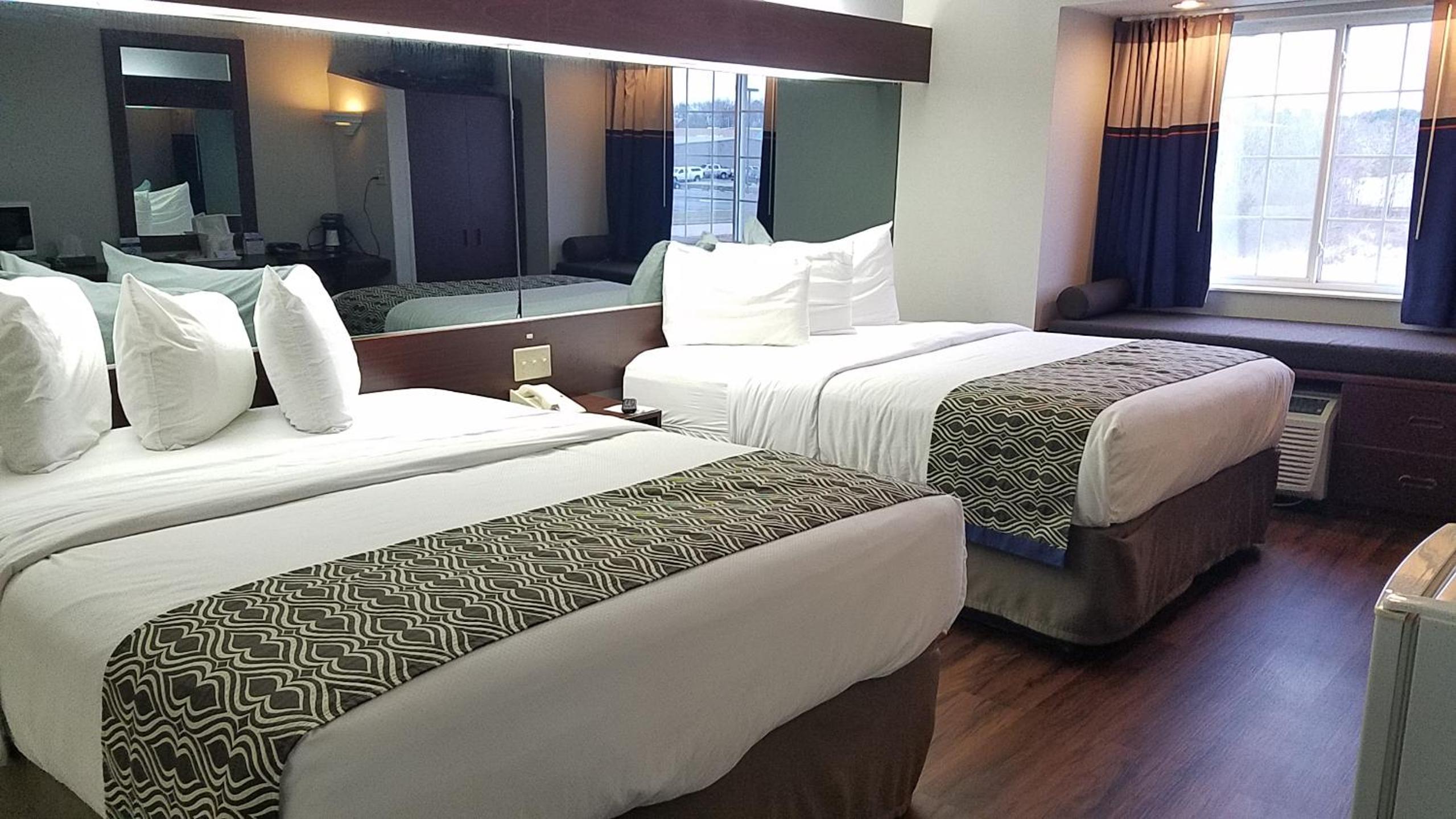 hotel room with two queen sized beds and a flat screen tv