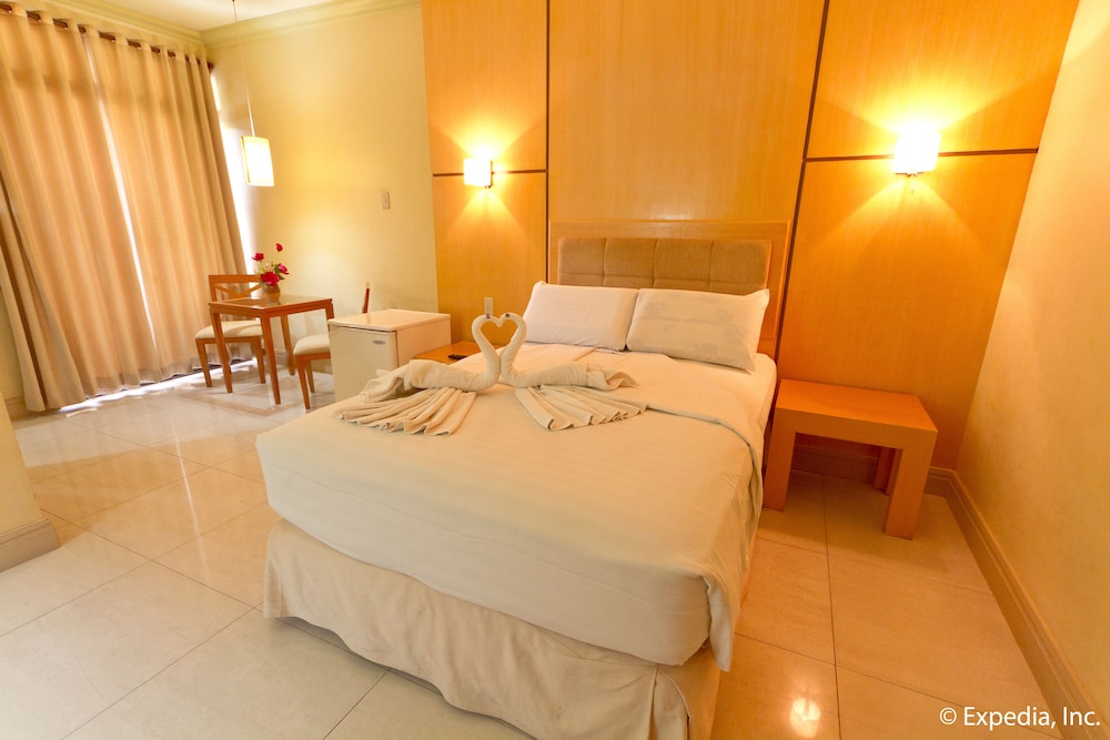 hotel room with an open door and two towels on the bed