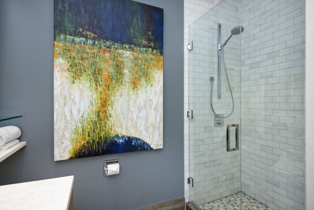 Modern bathroom with glass shower and abstract art