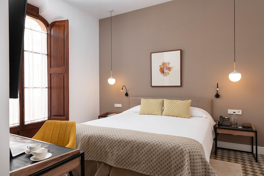 hotel room with a bed, desk, and chair
