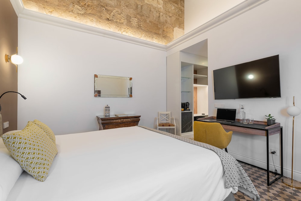 hotel room with a bed, desk, and television