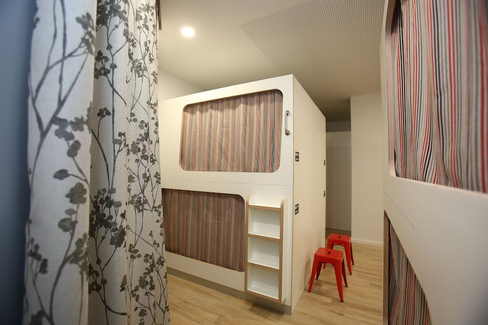 Cama individual en dormitorio compartido de 20 camas con baño compartido.