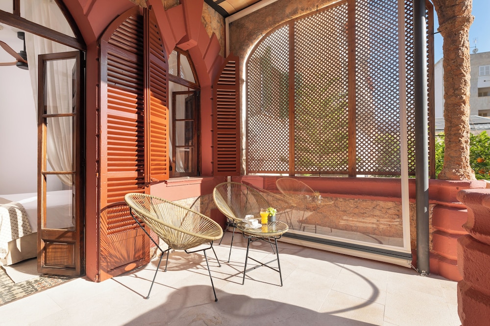 balcony with two wicker chairs and a glass table