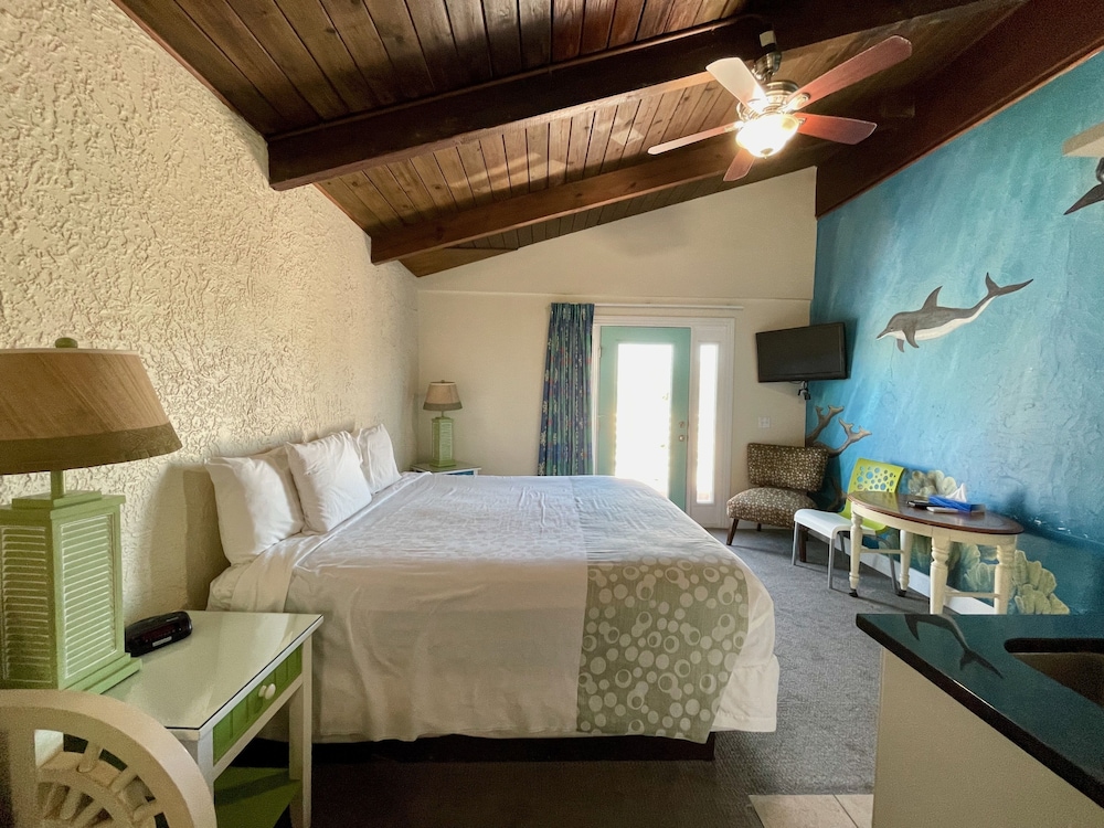 Habitación de lujo con cama king, vista limitada al mar, balcón y bañera de hidromasaje.