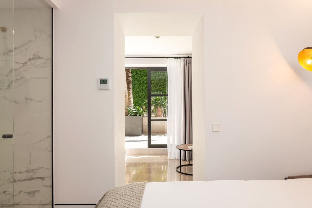 white bedroom with marble floors and a large glass door