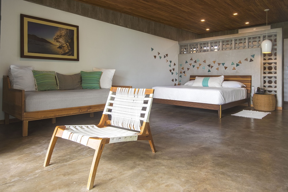 Habitación King Deluxe, 1 cama King con sofá cama, vista a un exuberante y vibrante jardín tropical.