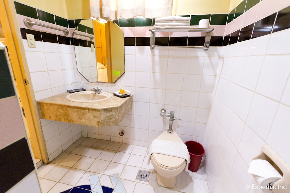 bathroom with white tile and black accents? it looks like the rest of an old hotel