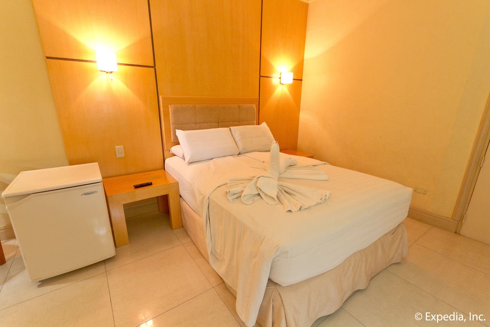 hotel room with an unmade bed and white towels on the bedspread