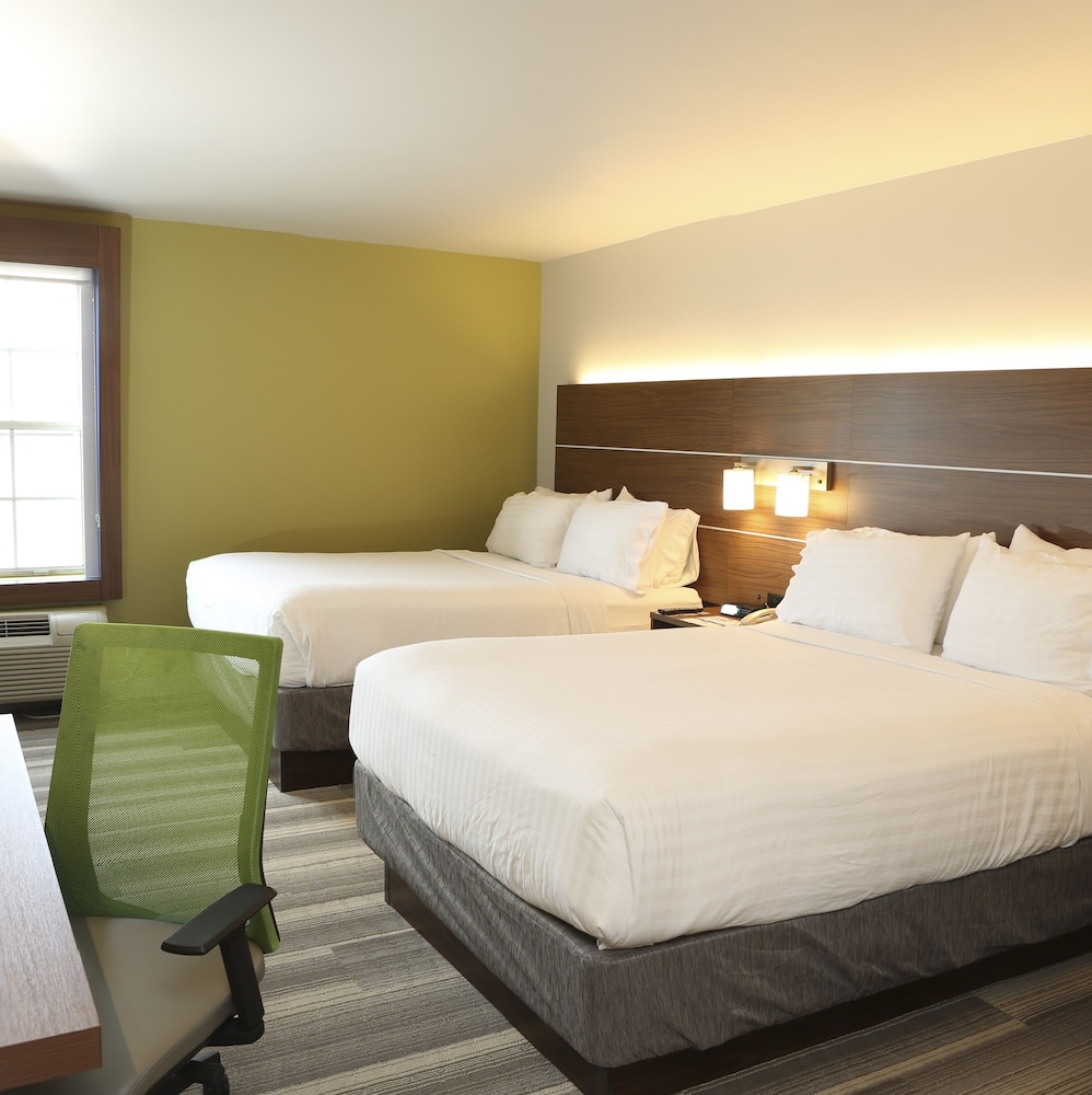 hotel room with two double beds and a green chair