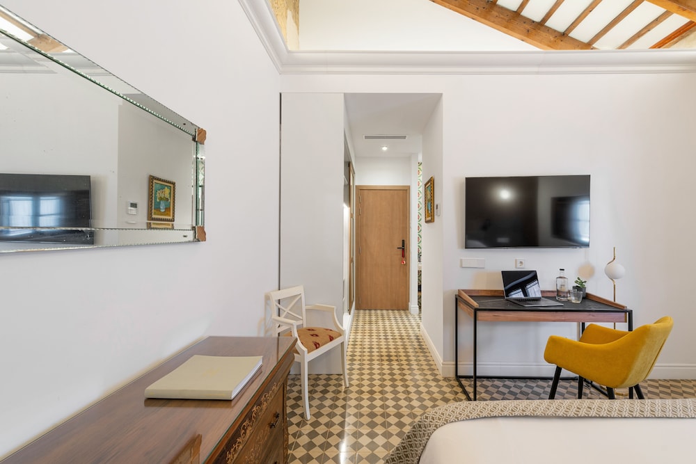 room with a bed, desk, chair and television