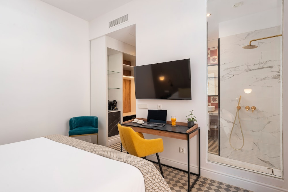 room with a bed, desk, tv, and chair