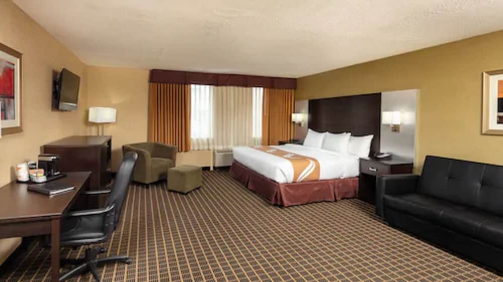 hotel room with a couch, desk, and bed