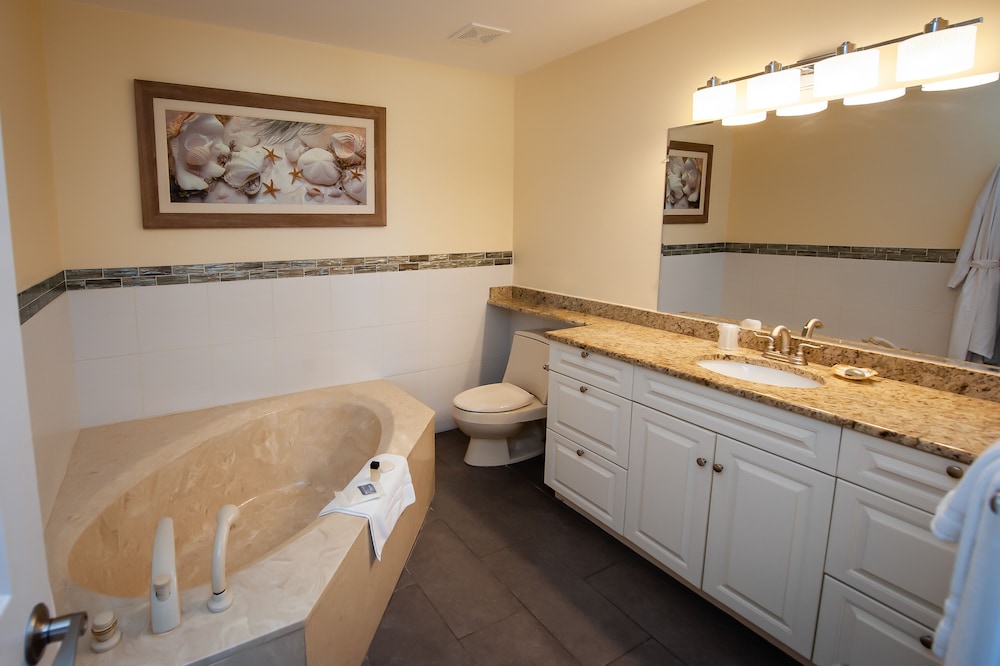 Bathroom with corner tub, toilet, and double vanity