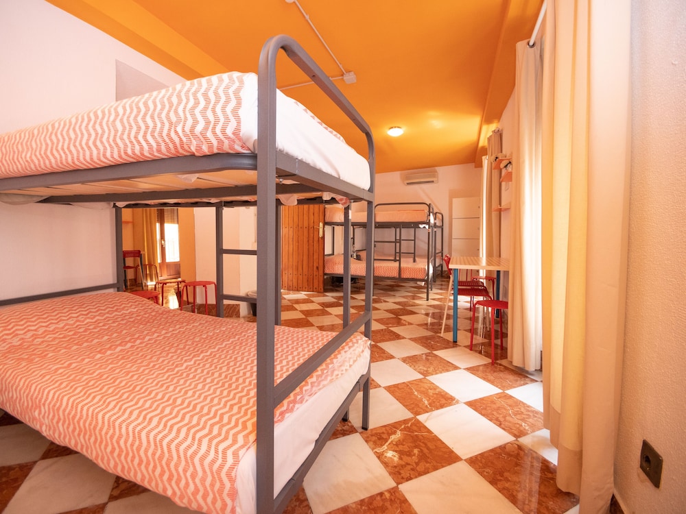 Cama en dormitorio mixto de 10 camas con baño compartido.