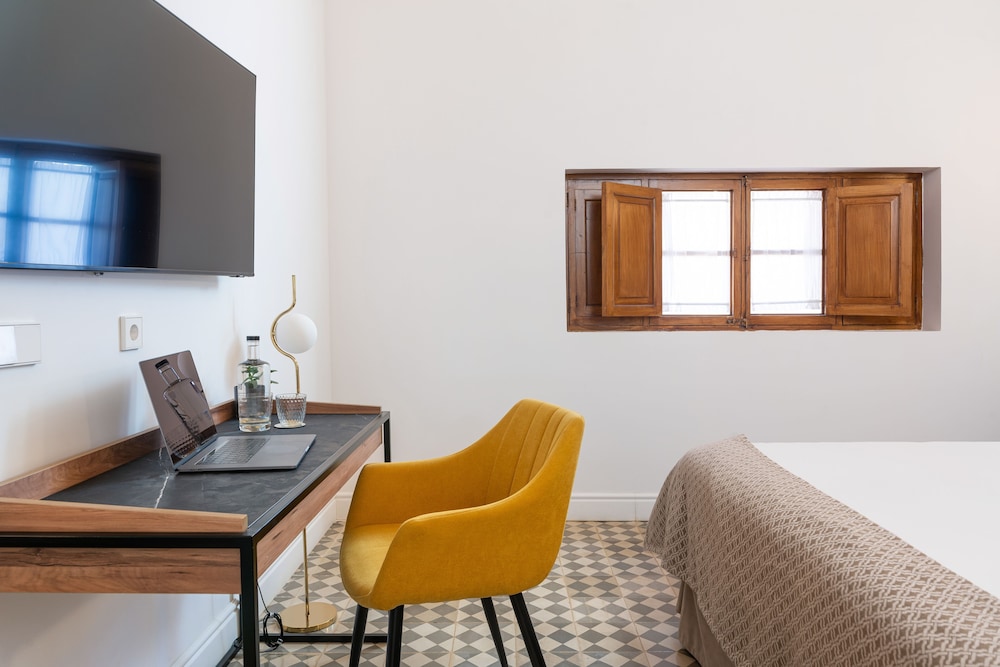 hotel room with a bed, desk, and television
