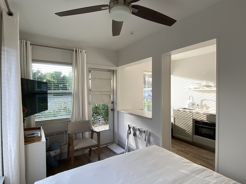 Bedroom with bed, chair, TV, and kitchenette