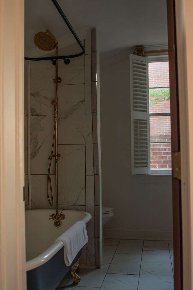 bathroom with a tub, shower head, and window