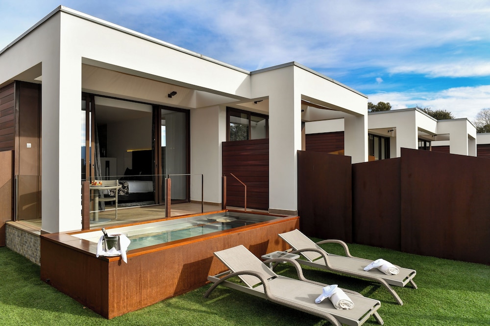 Suite con bañera hidromasaje y piscina climatizada exterior
