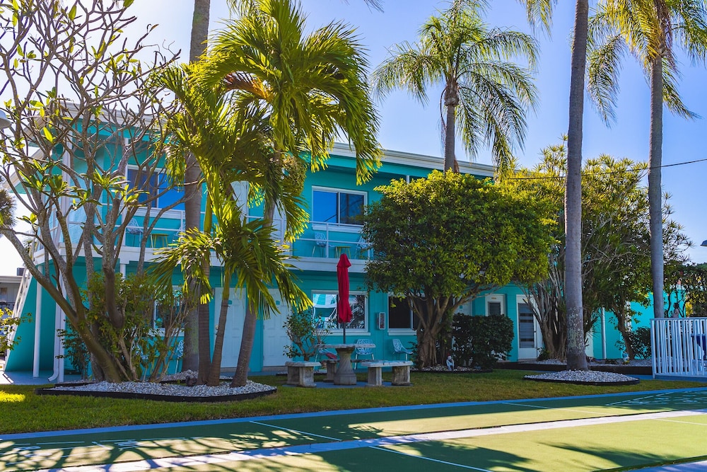 Tropical hotel exterior with palm trees and tennis court