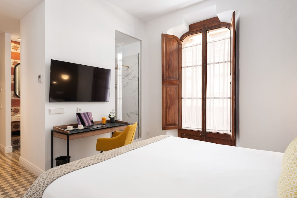 hotel room with a bed, desk, and tv