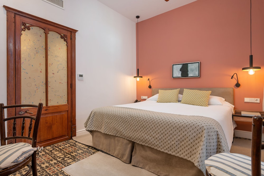 bedroom with a bed and two chairs in front of it
