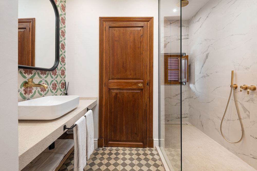 walk - in shower and a marble tiled bathtub
