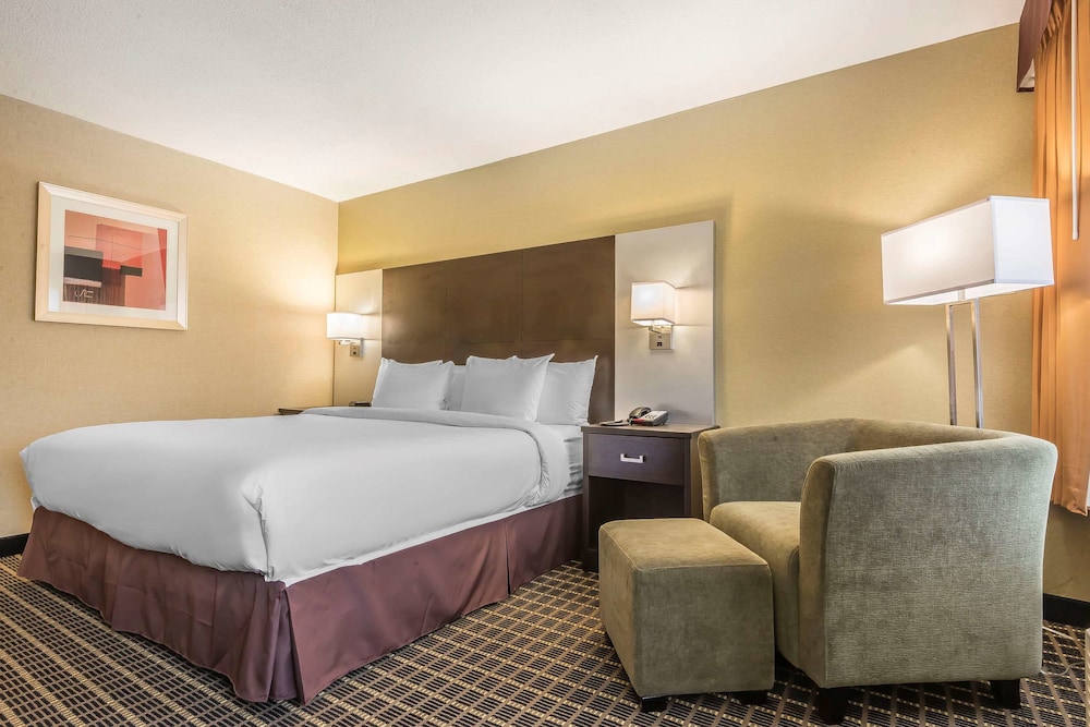 hotel room with a king size bed and two chairs