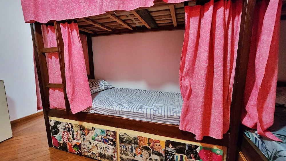 Cama em dormitorio feminino com 8 camas e ventilador