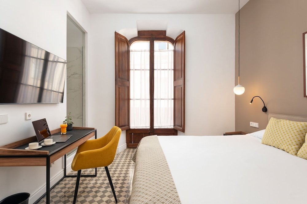 hotel room with a bed, desk, and television