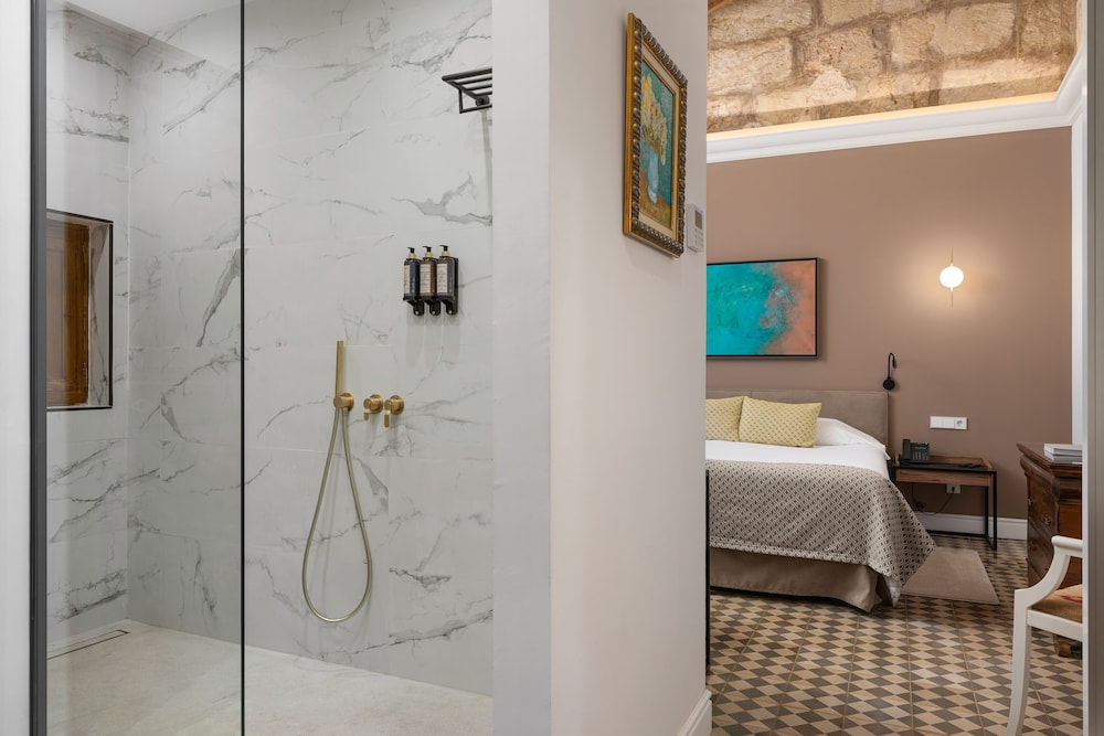 bathroom with a shower and a bed in the background