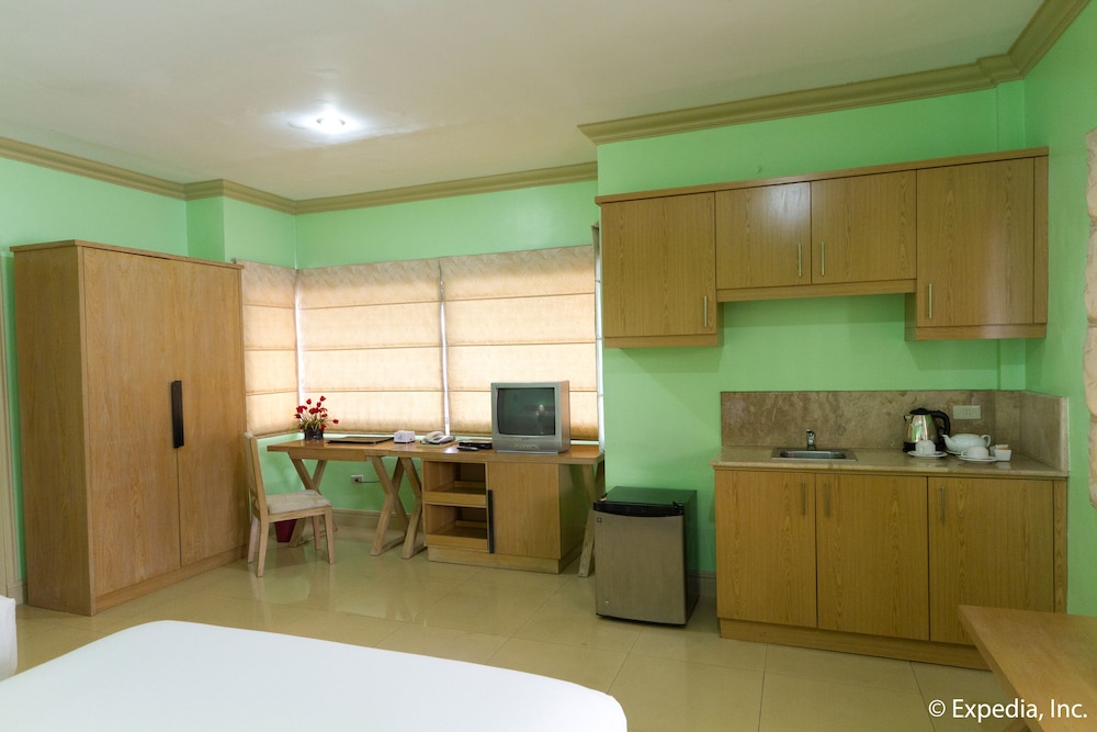 green room with wood cabinets and desks, including the television
